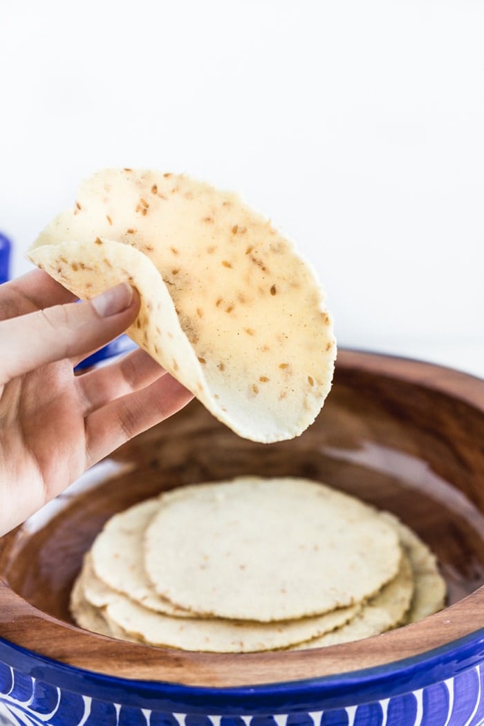 homemade corn tortilla folded in a person's hand