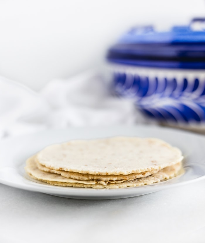 homemade corn tortillas stacked on a plate