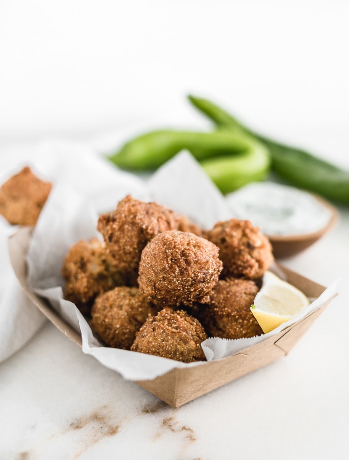 Hushpuppies in a bowl with a lime wedge.