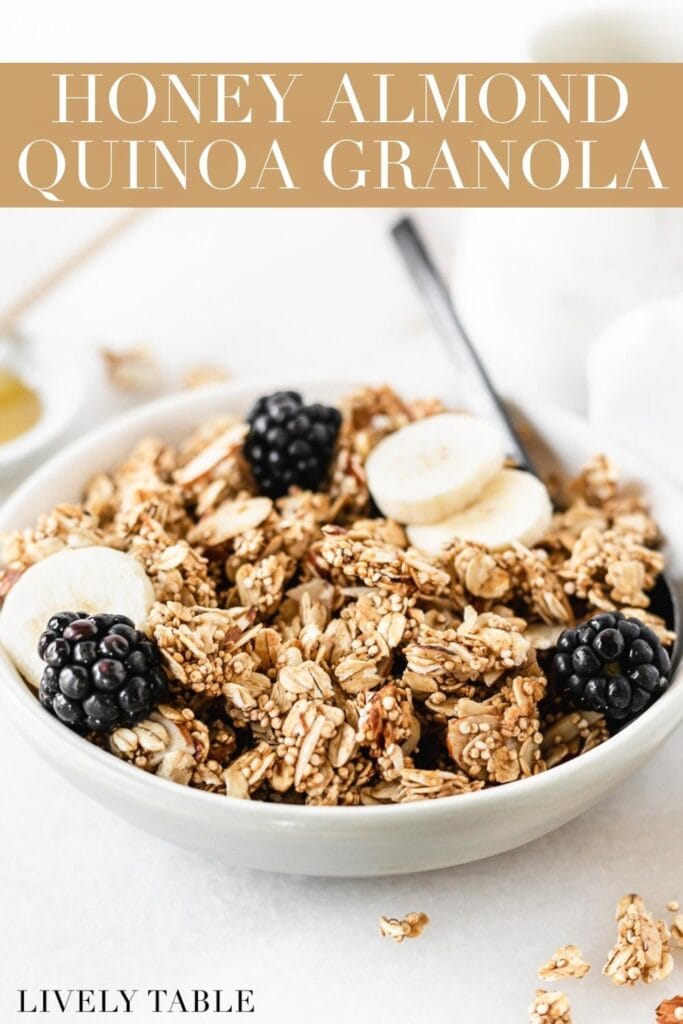 bowl of honey almond quinoa granola topped with blackberries and banana slices with text overlay.