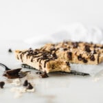 Closeup of one homemade chocolate chip cookie protein bar with a bite taken out of it.