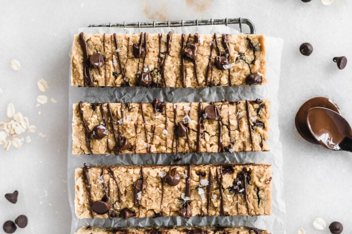 closeup overhead view of chocolate chip cookie chickpea protein bars drizzled with chocolate and sprinkled with sea salt.