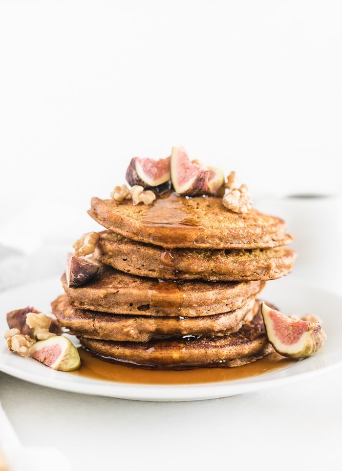 Healthy oatmeal pumpkin pancakes with walnuts, figs, and syrup.