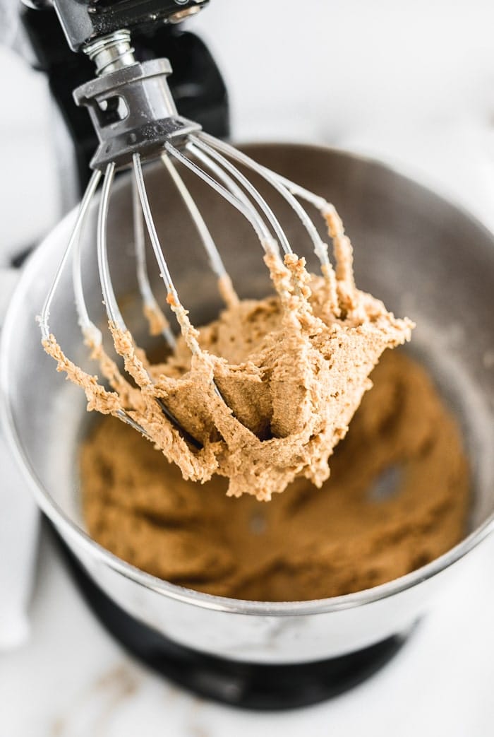 pumpkin snickerdoodle cookie dough in the whisk of a stand mixer.