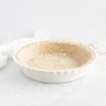 The best whole wheat pie crust in a white pie dish.