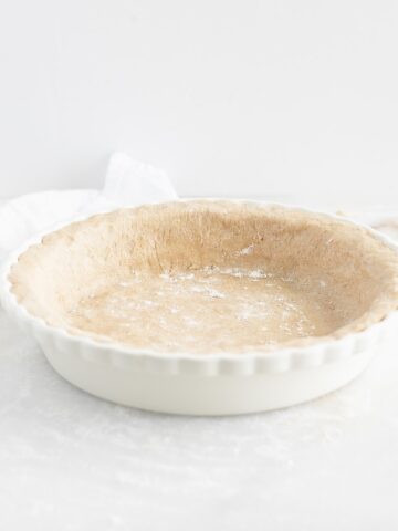 The best whole wheat pie crust in a white pie dish.