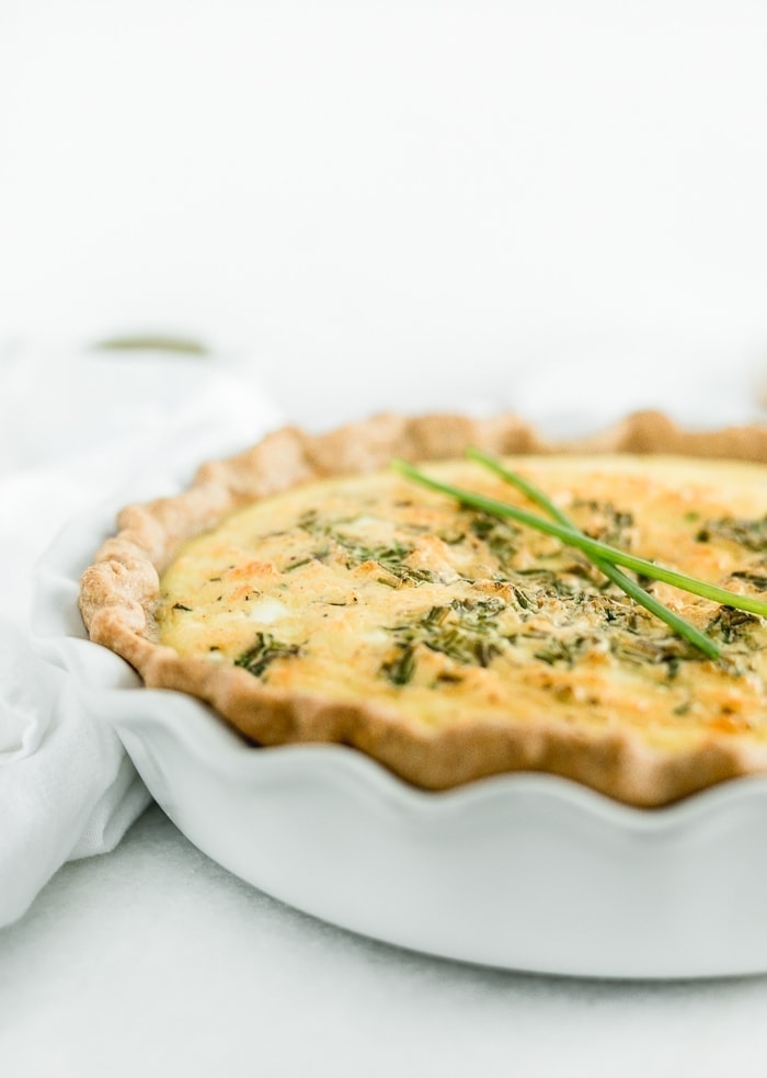 Closeup of Eggs Benedict Quiche in a white pie dish.