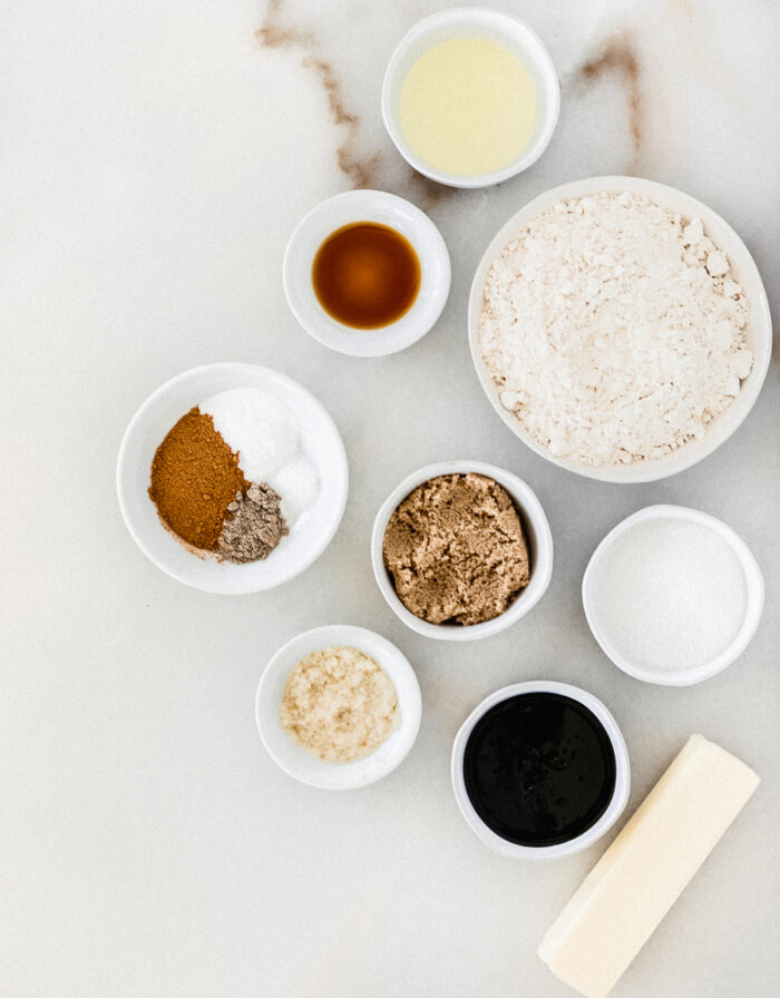 Overhead view of ingredients needed to make gingersnaps on a white background.