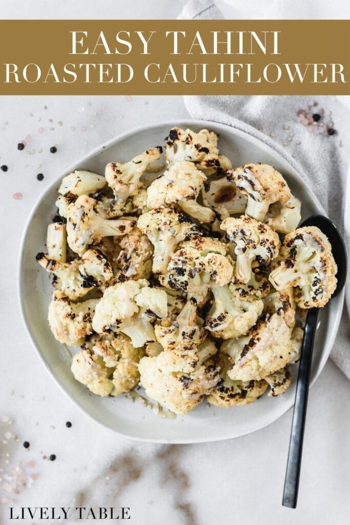 overhead view of tahini roasted cauliflower with tahini drizzle on a grey plate with a black spoon in it with text overlay.