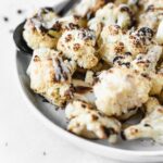 closeup of Tahini roasted cauliflower drizzled with tahini.