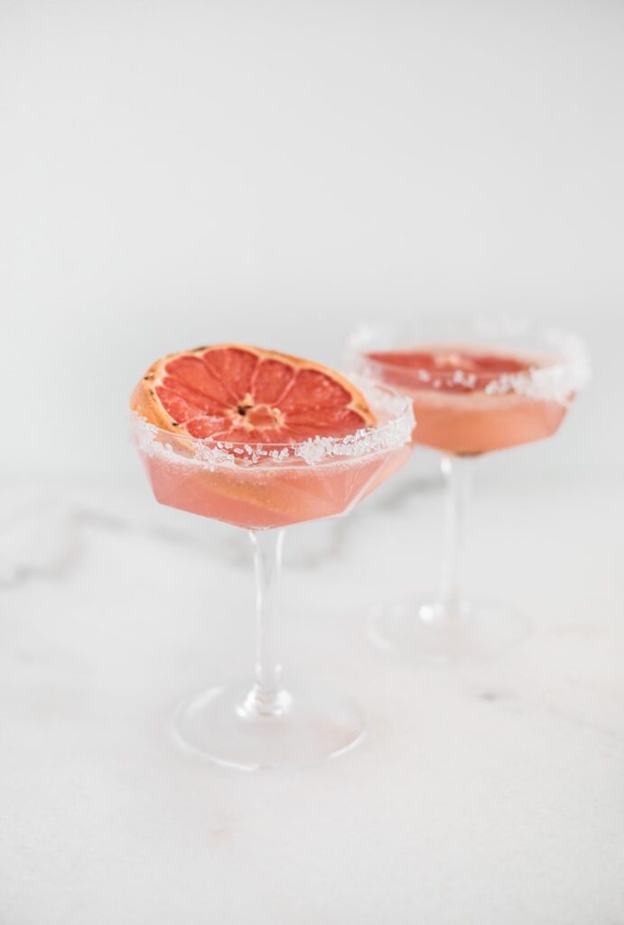 broiled grapefruit paloma in a vintage martini glass with sparkling sugar on the rim.