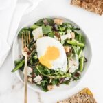 overhead view of spring breakfast salad on a white plate with a white napkin next to it.