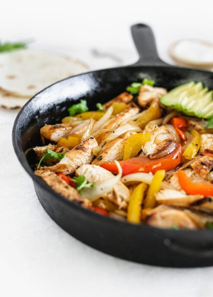 steak and chicken fajitas close up in cast iron fajita skillet