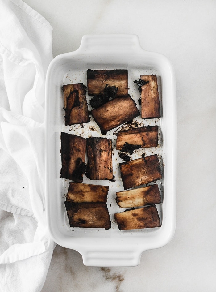 overhead view of roasted beef short rib bones in a white baking dish.