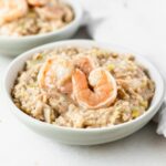 closeup of a bowl of shrimp and leek brown rice risotto.