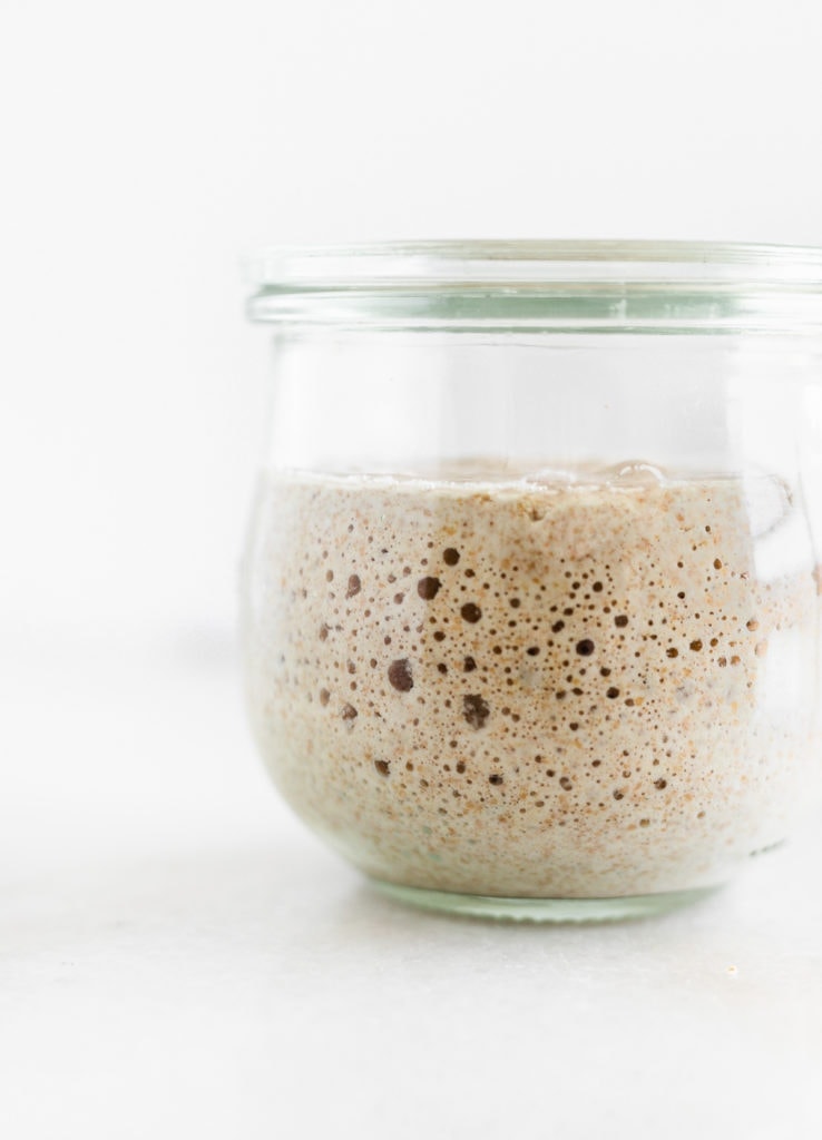closeup of sourdough starter in a glass jar.