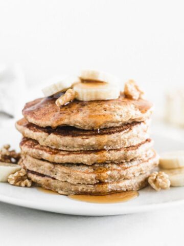 banana oatmeal pancakes with walnuts and banana slices on top.