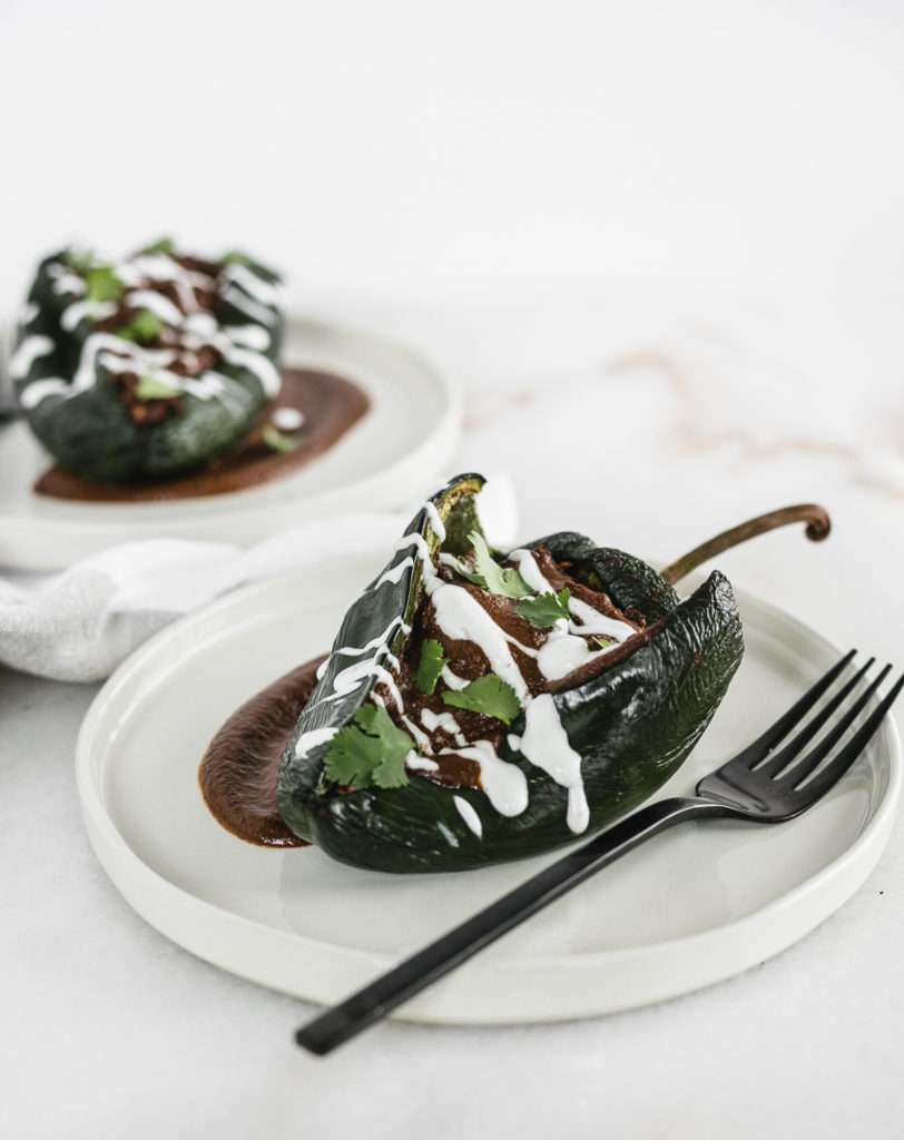 Chicken mole relleno on a plate with a fork.