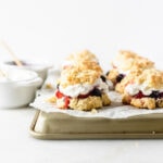 red white and blue berry shortcakes on a parchment lined tray.