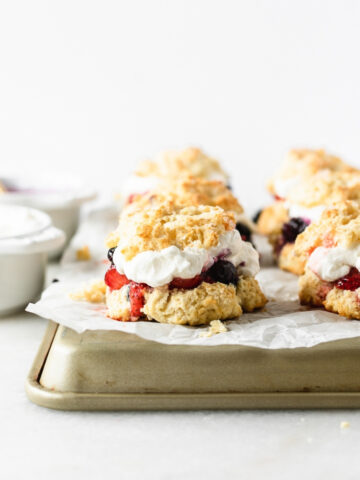 red white and blue berry shortcakes on a parchment lined tray.