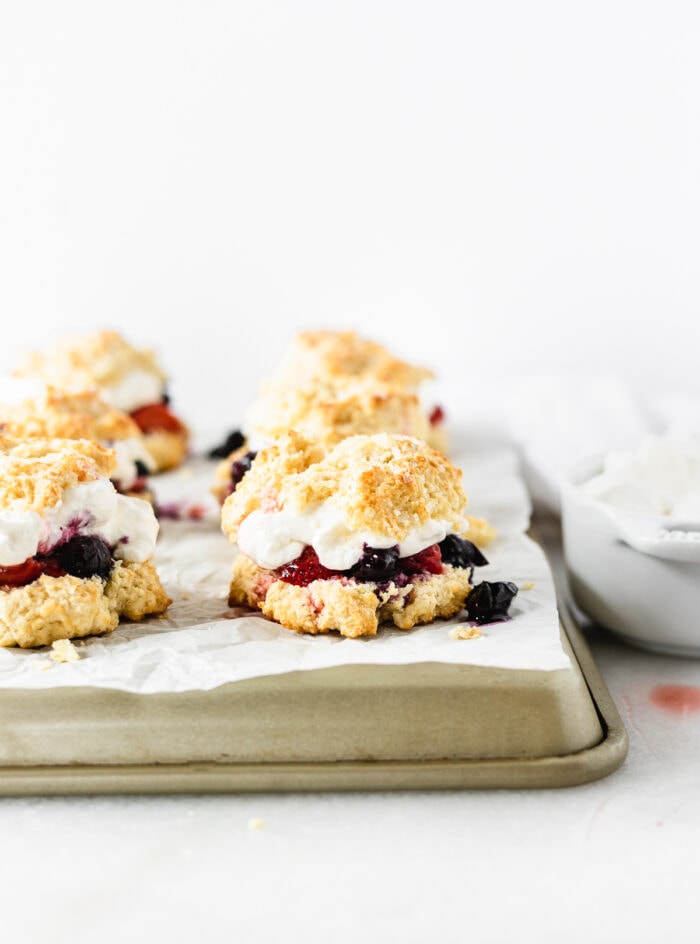 red white and blue berry shortcakes on a parchment lined tray.