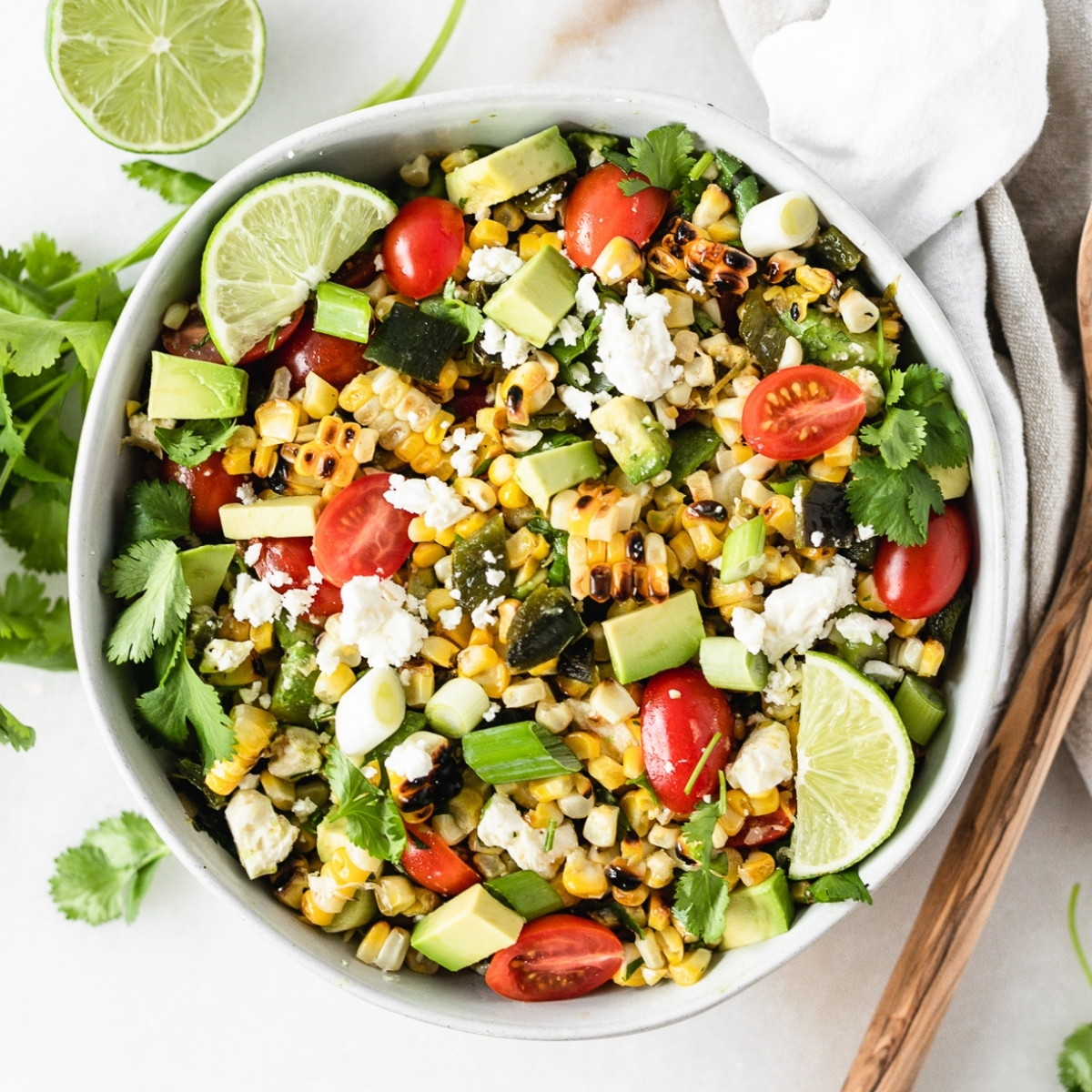 This grilled corn summer salad features grilled fresh corn and poblanos with fresh tomatoes and avocado for a delicious summer salad that's perfect for cookouts! (gluten-free, vegetarian) | via livelytable.com