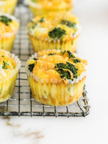 closeup of broccoli cheddar egg muffins on a wire cooling rack.
