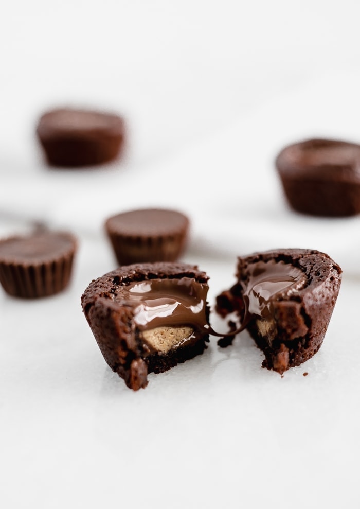 mini peanut butter cup brownies on parchment paper on a wire cooling rack.