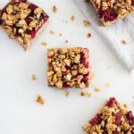 overhead view of no added sugar pbj oatmeal bars on a white counter and gray napkin.