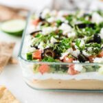 closeup of 7 layer greek dip in a square glass container.