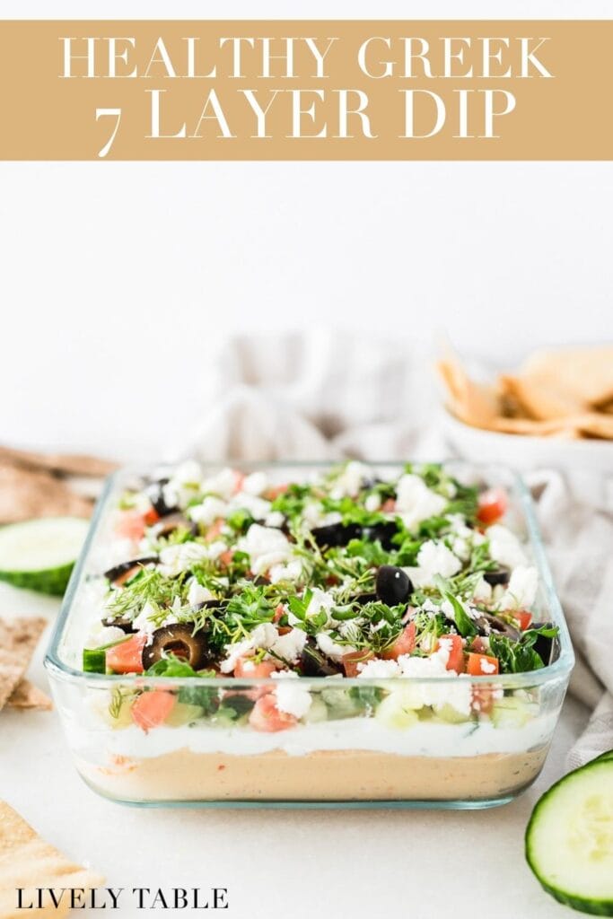 healthy 7 layer greek dip in a square glass dish with text overlay.