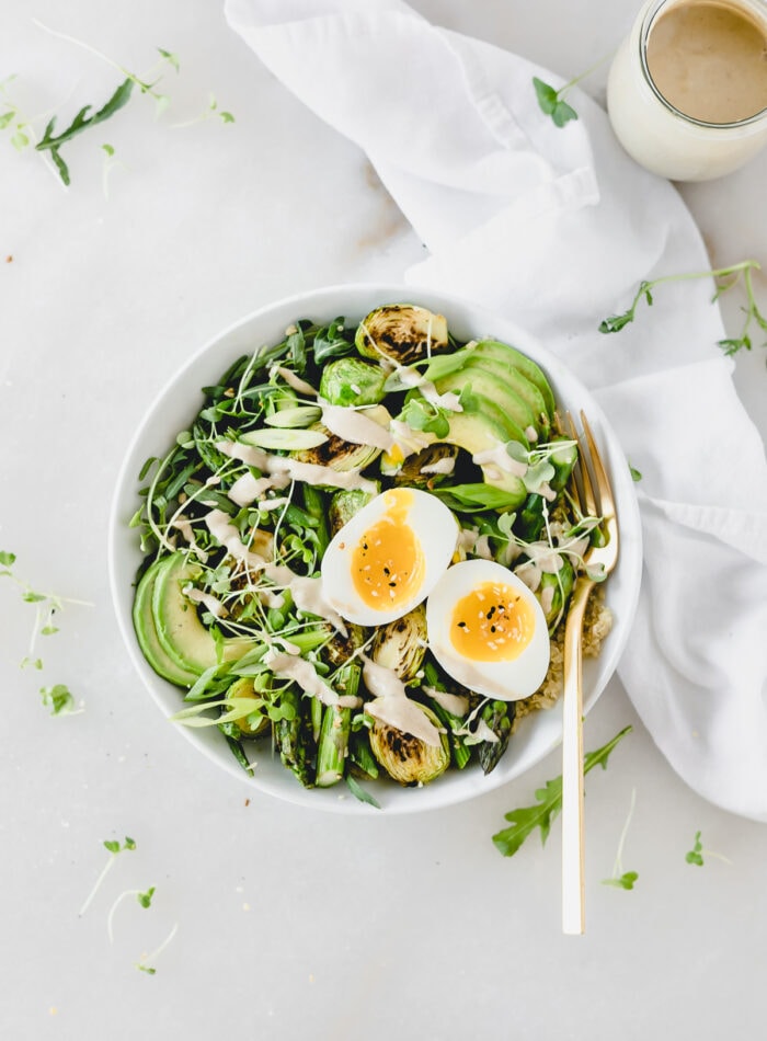 overhead view of spring green grain bowl with a soft boiled egg on top.