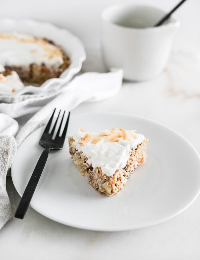 A slice of healthy carrot cake baked oatmeal on a plate with a fork.