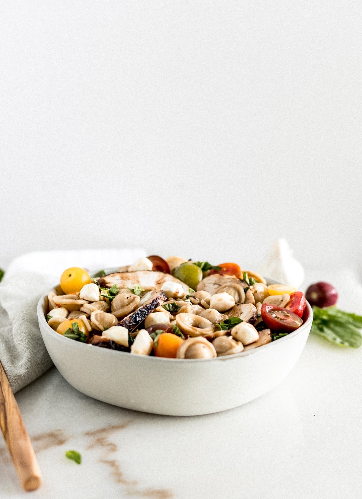 This Chicken Caprese Pasta Salad is a delicious and healthy pasta salad made with tomatoes, basil, mozzarella and whole grain pasta that makes the perfect summer lunch or potluck dish! (gluten-free and vegetarian option) | via livelytable.com