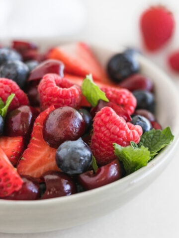 Closeup of patriotic summer fruit salad in a white bowl.