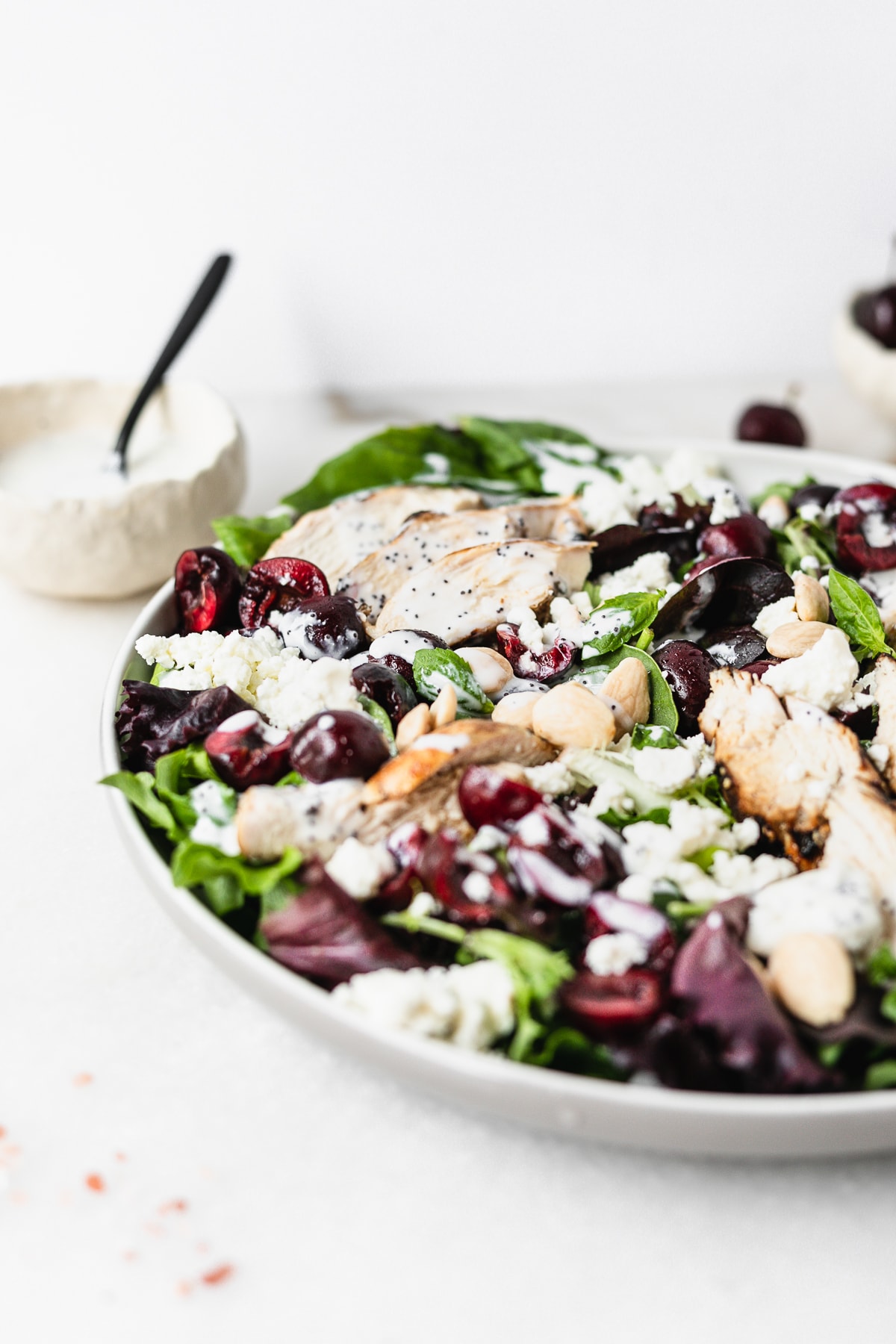 closeup of cherry almond grilled chicken salad drizzled with creamy poppy seed dressing.