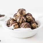 Quinoa peanut butter cup protein balls stacked in a round white dish.