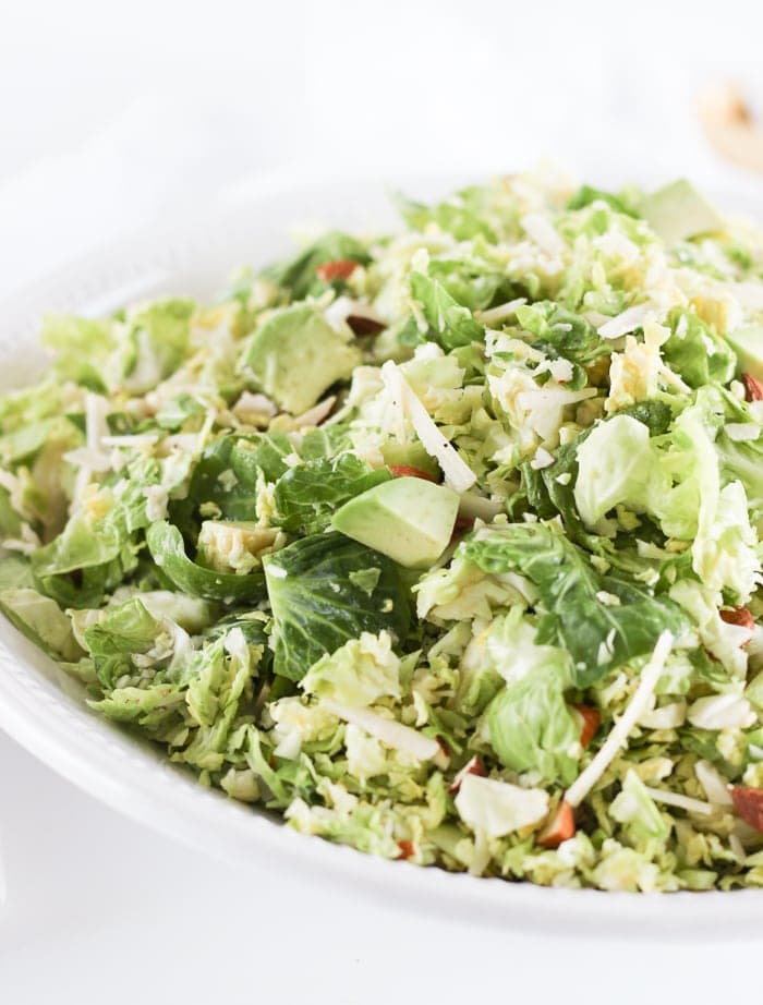 This healthy shaved brussels sprout salad with parmesan, almonds,avocado and a citrus shallot vinaigrette is the perfect hearty winter salad to go with all of your meals! (gluten-free, vegetarian)