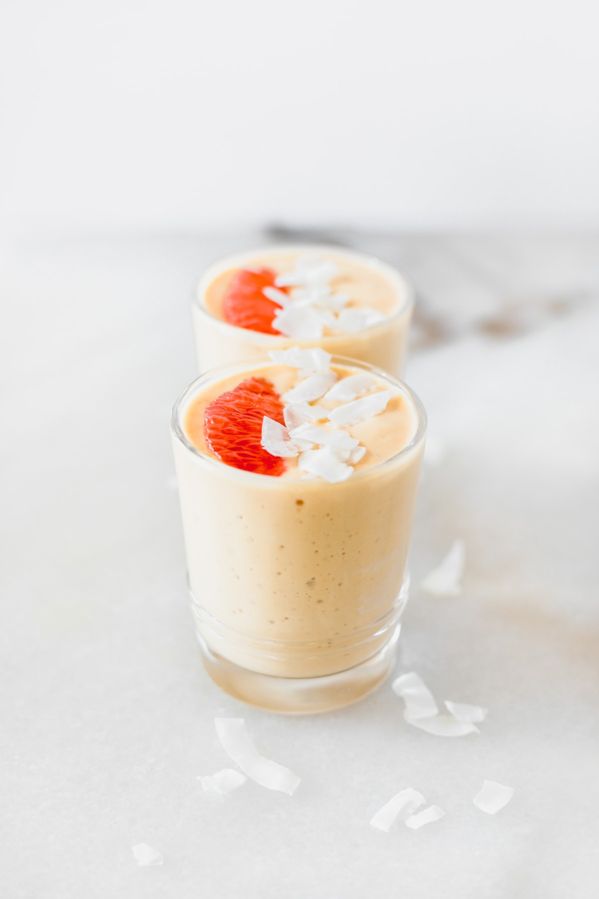 nutrient-packed immune-boosting grapefruit mango smoothie with turmeric in two glasses