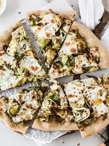 overhead view of sliced caramelized onion brussels sprout pizza.