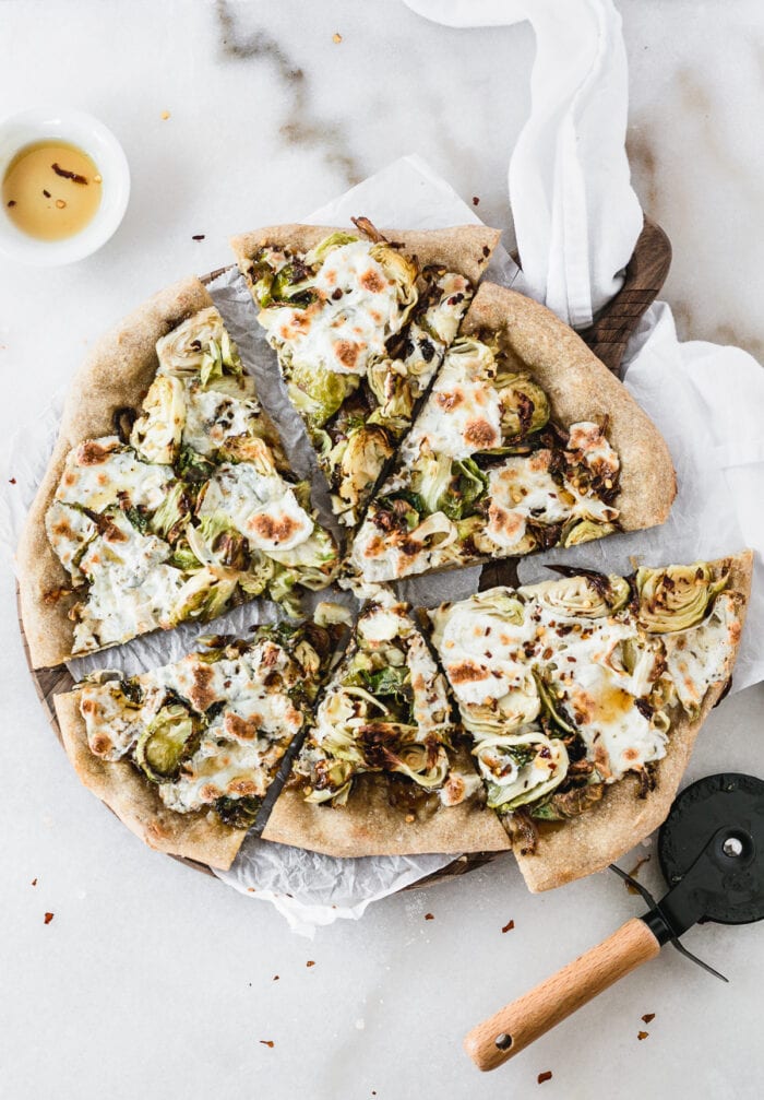 overhead view of sliced caramelized onion brussels sprout pizza.