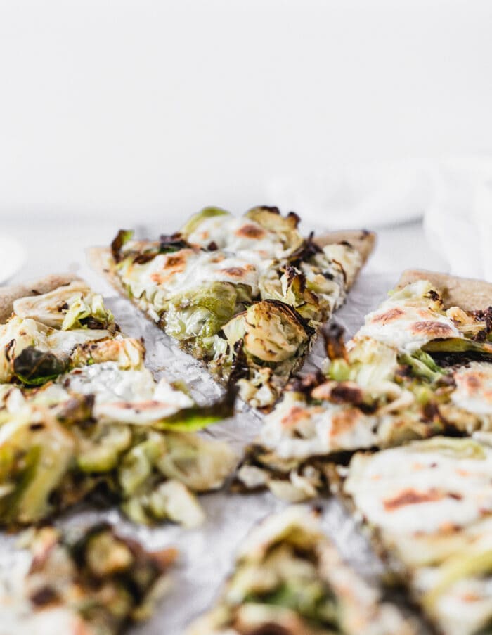 closeup of a slice of caramelized onion brussels sprout pizza.