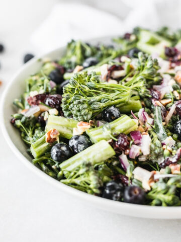 closeup of broccolini superfood salad in a white bowl.