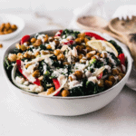 Moroccan chickpea kale salad drizzled with tahini dressing in a grey bowl.