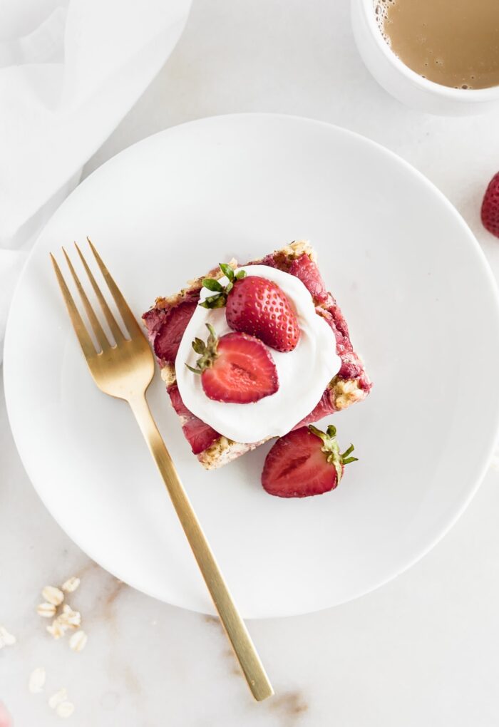 A slice of strawberry baked oatmeal on a white plate.