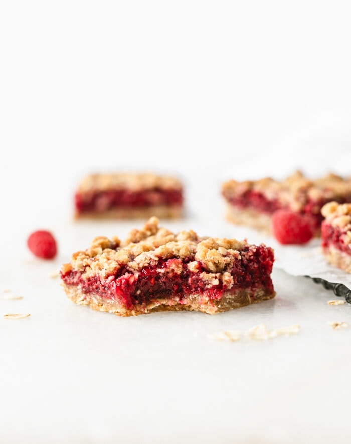 Raspberry Oat Crumble Bar with a bite taken out of the corner.