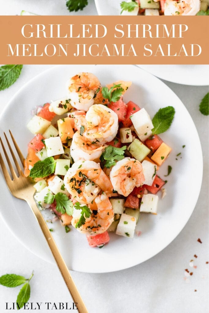 overhead view of grilled shrimp and jicama melon salad on a white plate with a gold fork with text overlay.