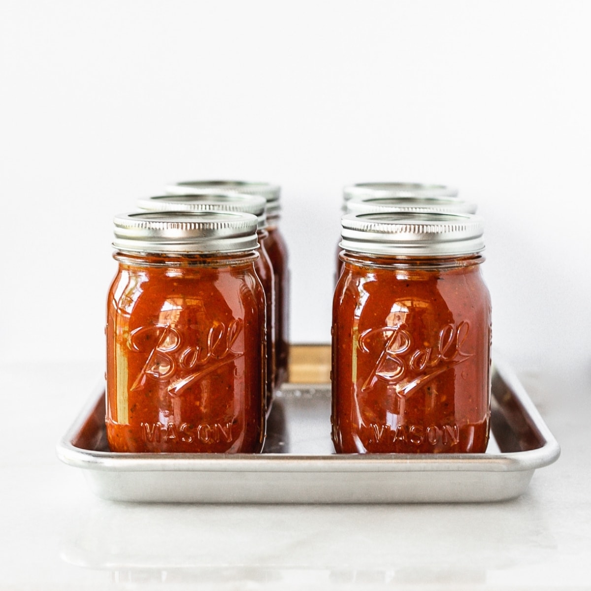 jars of spaghetti sauce lined up on a tray.