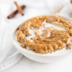 closeup of Maple Pumpkin Spice Oatmeal in a white bowl topped with milk.
