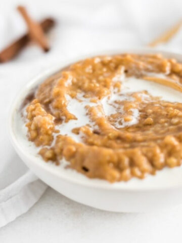 closeup of Maple Pumpkin Spice Oatmeal in a white bowl topped with milk.